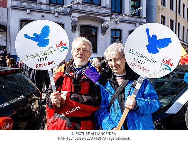 02 April 2018, Germany, Hamburg: Participants of the Easter march 2018 carry signs reading 'Krankenhaeuser statt Kanonen' (lit