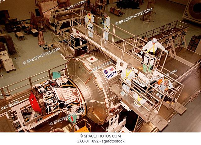 10/22/1998 --- In the Space Station Processing Facility, workers look over the Unity connecting module, part of the International Space Station