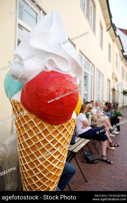 17 June 2023, Lower Saxony, Osnabrück: A display in the shape of a giant ice cream cone stands in front of an ice cream parlor
