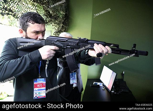 RUSSIA, MOSCOW - DECEMBER 17, 2023: Chechen Parliament Speaker Magomed Daudov holds a rifle at a stand at the Russia Expo international exhibition and forum at...