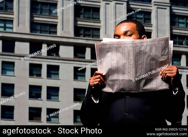 Businessman looking over newspaper