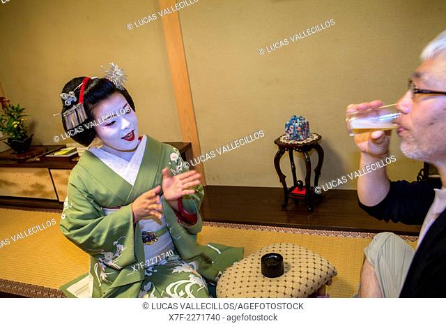 Fukukimi, 'maiko' (geisha apprentice) workimg (joking with a client) in Miyaki tea house (o-chaia).Geisha's distric of Miyagawacho.Kyoto