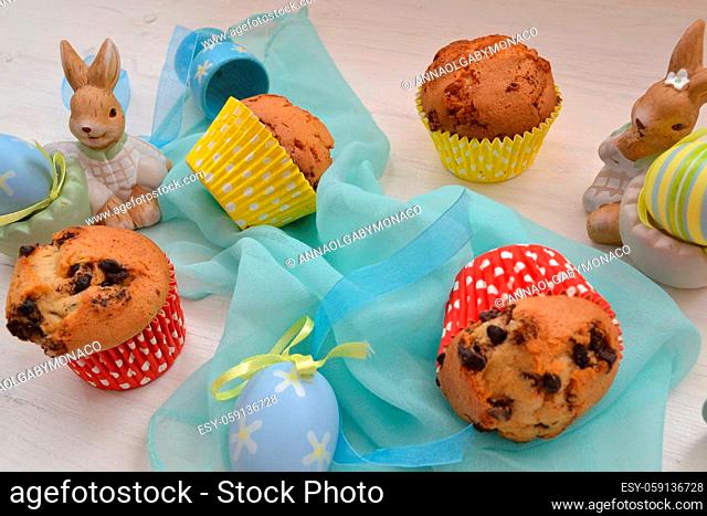 Easter decoration colored eggs, muffins and bunny on wooden table