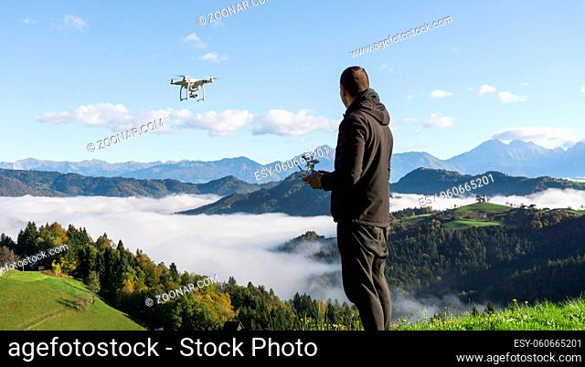 Man operating drone flying or hovering by remote control