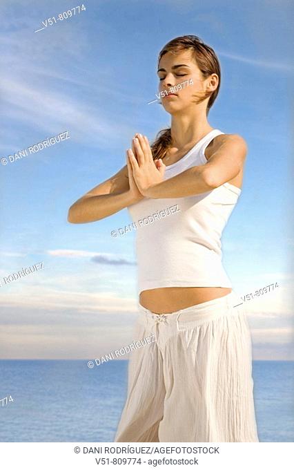 Woman doing yoga by the sea