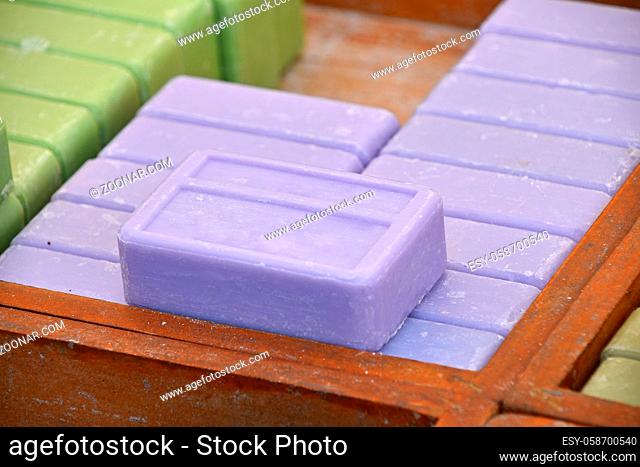 Close up blue lavender traditional beauty toilet hard soap bars in wooden box on retail display, high angle view