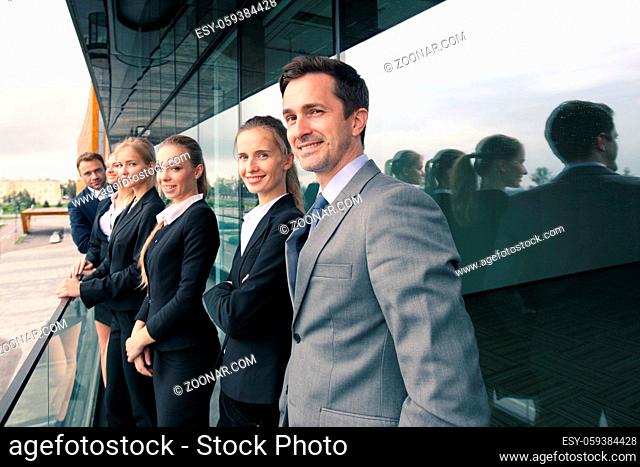 Business people team standing in a row at the balcony of modern office building toned image