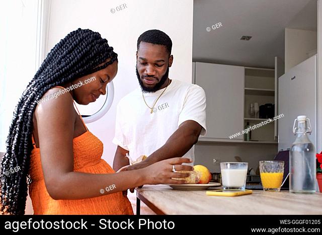 Man taking care of pregnant woman at home