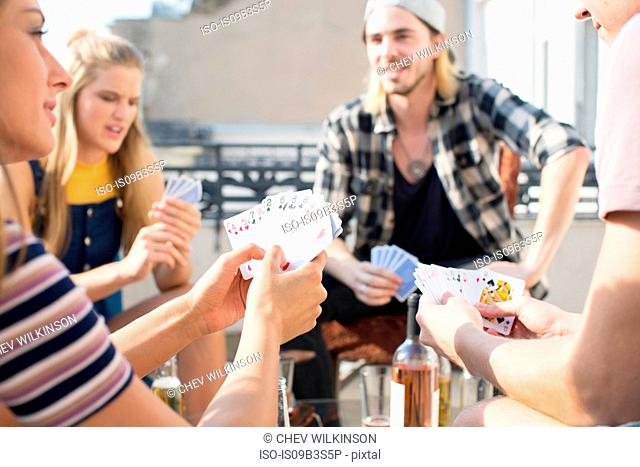 Young adults playing card game at roof terrace party, Budapest, Hungary