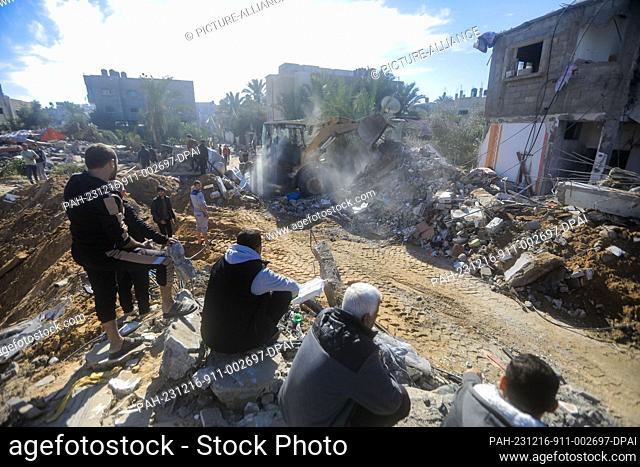 16 December 2023, Palestinian Territories, Rafah: Palestinians inspect the debris removal from destroyed buildings following the Israeli bombing of Rafah in the...