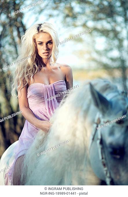 Marvelous woman riding a white horse