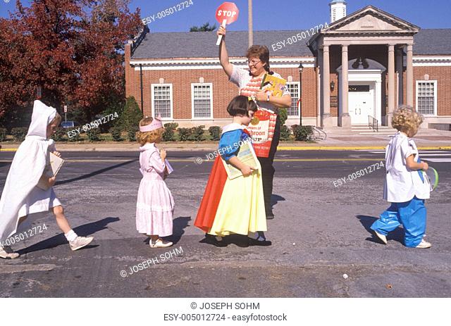 School crossing guard helping children in Halloween costumes, Webster Groves, Missouri