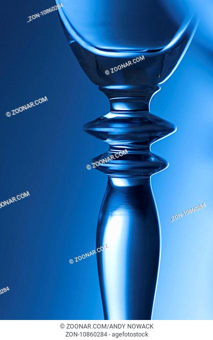 Detail-Ansicht des mittleren Teils eines Sektglases mit Helligkeits-Verlauf im Hintergrund; blau getont