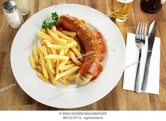 Sausage in curry sauce with French fries and beer