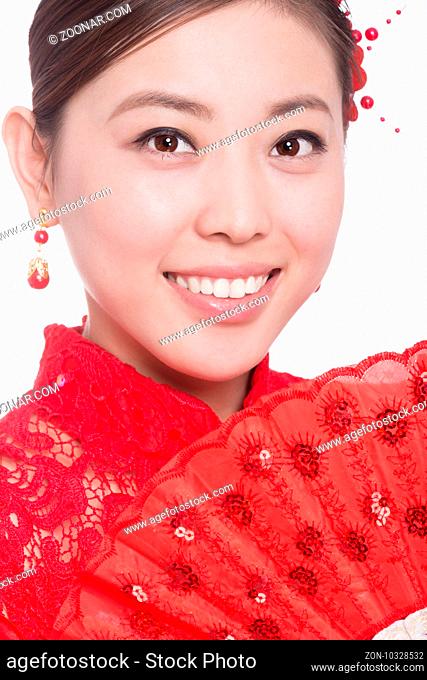 young asian woman in red cheongsam holds paper fan in chinese new year