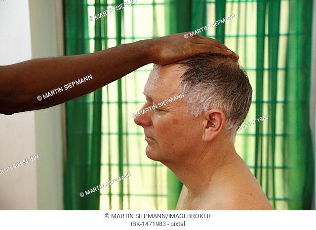 Laying a hand on a man's head, preparation for Ayurvedic treatment, Bethsaida Hermitage near Kovalam, Kerala, southern India, India, Asia