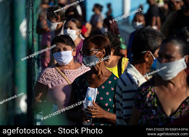 22 March 2021, Brazil, Duque De Caxias: People over the age of 70 line up outside a vaccination center where they will be administered a Corona vaccine