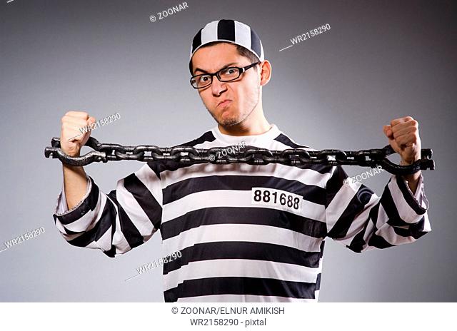Funny prisoner in chains isolated on gray