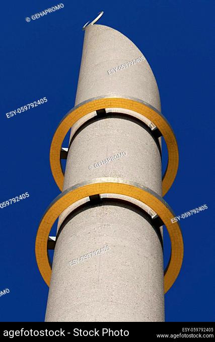 minaret of the mosque of cologne with the two golden rings in front of a dark blue sky