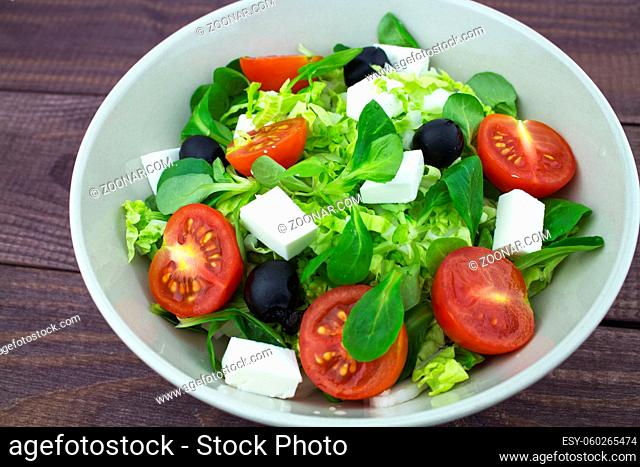 Salad, fresh tomatoes greens olives feta cheese close-up. Classic Greek salad with fresh vegetables