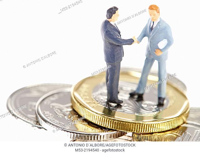 Two businessman shaking hands on Singapore coins