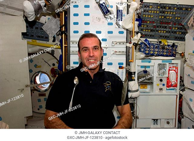 NASA astronaut Rick Mastracchio, STS-131 mission specialist, is pictured near a spoon and food package floating freely on the middeck of space shuttle Discovery...