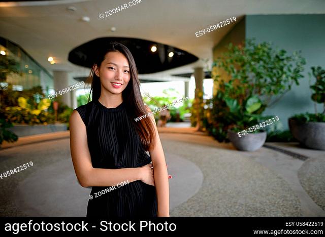 Portrait of young beautiful Asian businesswoman at the indoor garden