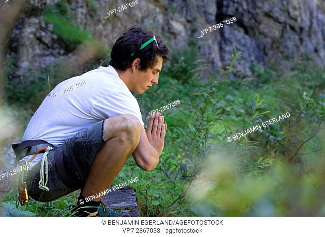 young outdoor sportsman praying in nature, in south of Germany, Bavaria, near border to Austria