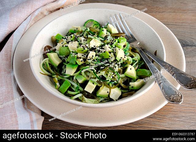 Salad from noodles from cucumbers and laminaria, slices of avocado with sesame