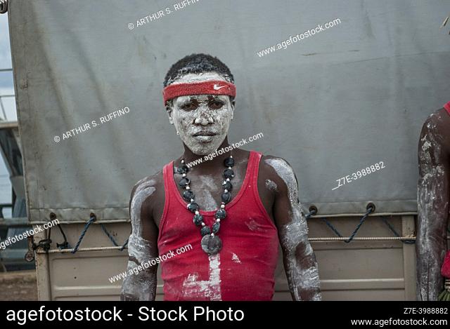 Member of a musical group in traditional dress adorned with sandelwood (masonjoany) powder poses for pictures at the pier in Nosy Be. Madagascar