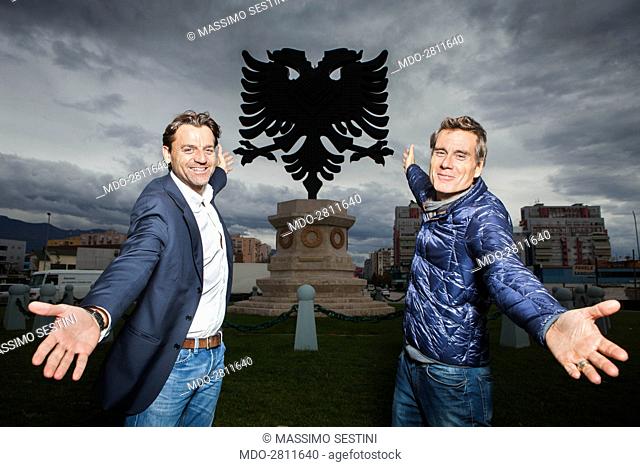 The journalist and presenter Alessio Vinci and the TV personality Jimmy Ghione posing in front a double-headed eagle monument