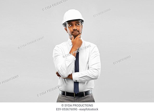 indian male architect in helmet over grey