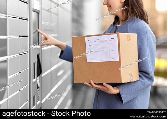 smiling woman with box at automated parcel machine