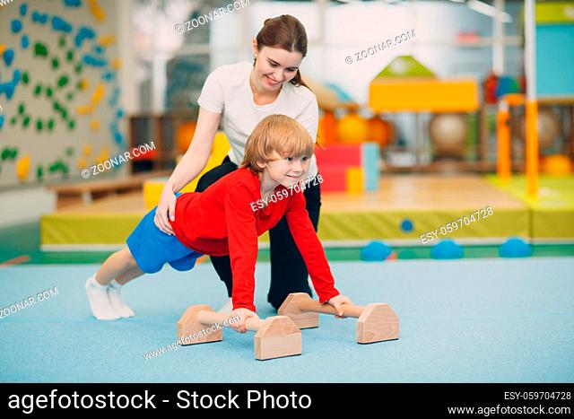 Kids doing exercises push up in gym at kindergarten or elementary school. Children sport and fitness concept