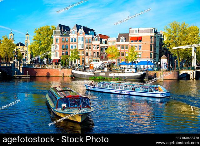 Amsterdam, Netherlands - April 19, 2017: Passenger boats on canal tour in the city of Amsterdam, Holland