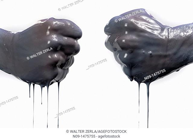 two fists with dark liquid