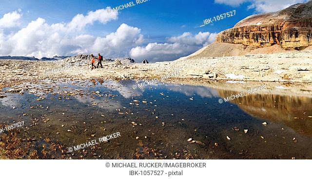 Hikers at a melt water lake on the Piz Boe peak on the Sella massif, Passo Sella, province of Bolzano-Bozen, Italy, Europe