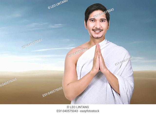 Religious asian muslim man praying with desert background
