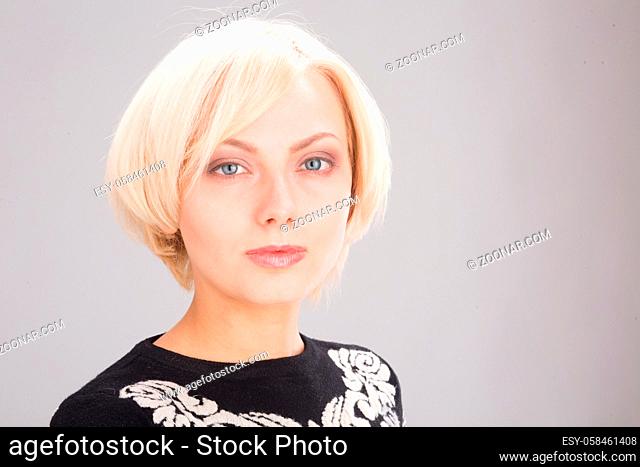 Closeup portrait of blond lady's face with pink lips and blue eyes in studio. Beautiful blond woman posing for photographer isolated on white