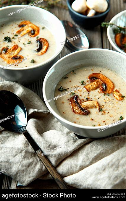 Two bowls with delicious mushroom soup on wooden table. Food photography