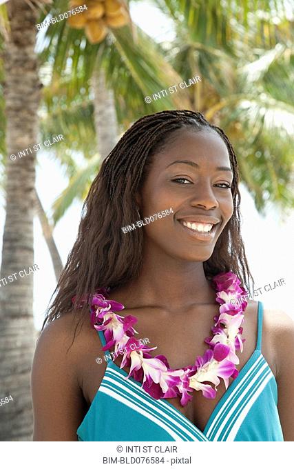 African woman wearing lei on beach