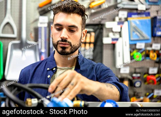Male hardware shop owner sorting out products