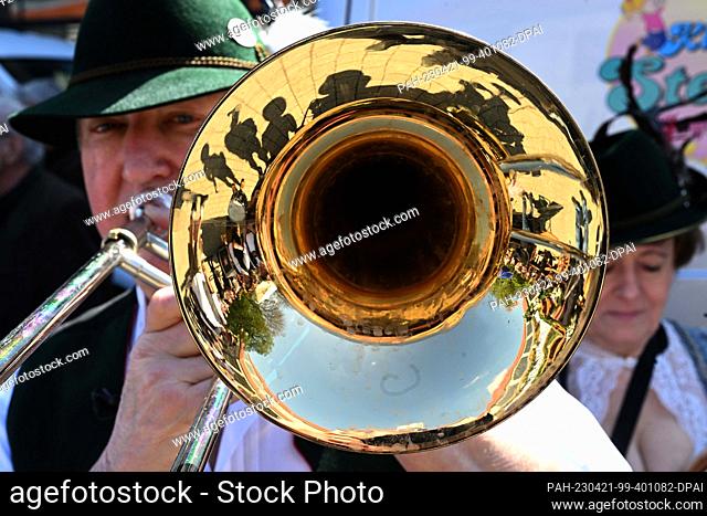 21 April 2023, Bavaria, Munich: A brass musician stands with his instrument shortly before the start of the Spring Festival on the Theresienhöhe