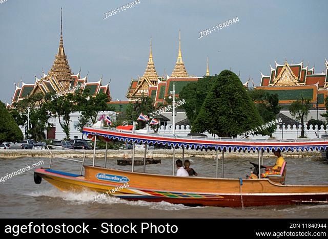 The Boat trafic in front of the Royal Palace and Wat Phra Kaew at the chao phraya river in the city of Bangkok in Thailand