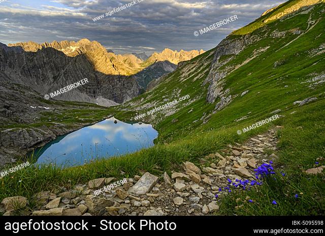 Mountain trail with Lake Guffelsee and Lechtal Alps in the morning light Gramais, Lechtal Außerfern, Tyrol, Austria, Europe