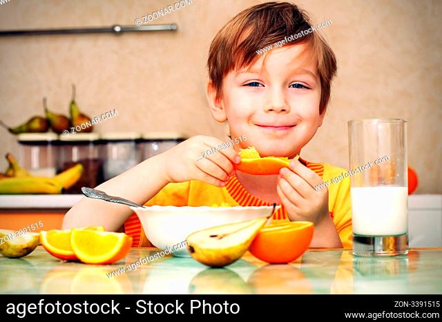 boy, breakfast, drinks milk, eats cereal and orange