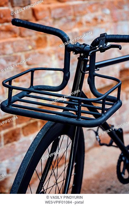 Cargo cage of acustomised commuter fixie bike at brick wall