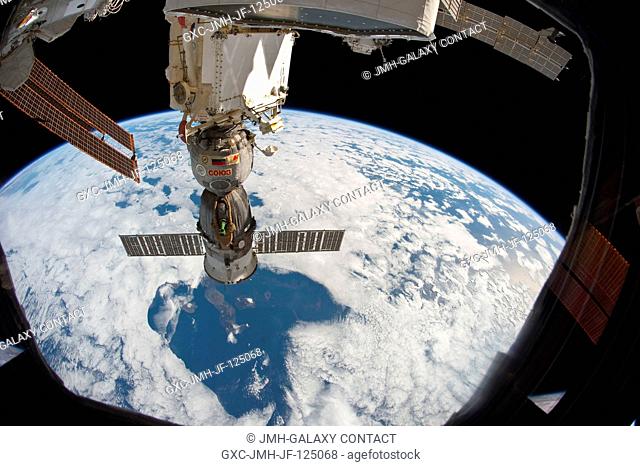 At 220 miles above Earth, the unattended Soyuz TMA-19 spacecraft, docked to the International Space Station, almost appears to be a giant telescope focusing...