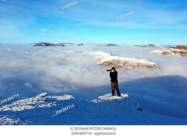 Hillwalker on Ben Challum photographing a cloud inversion