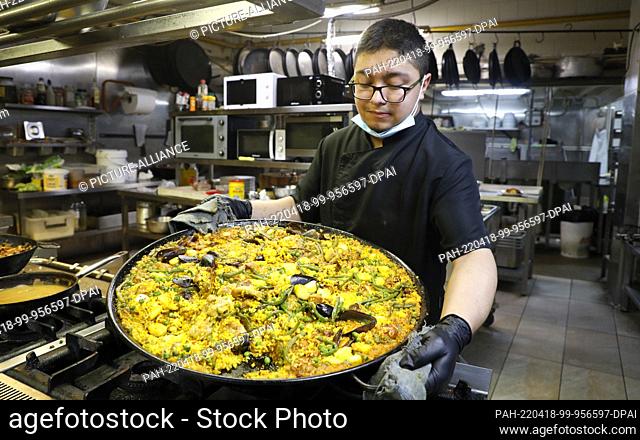 18 April 2022, Spain, Palma: Richard, chef of the restaurant ""Sa Premsa"" with typical Mallorcan cuisine, cooks traditional paella before opening for customers...